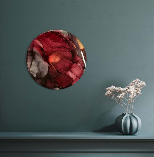 Hallway decor of maroon adorns a wall over a shelf - art symbolism inspired by the phoenix oracle card representing happiness and fulfilment - where clarity and drive pushes you through adversity and you successfully navigate your problems and fears.
A circular abstract painting.