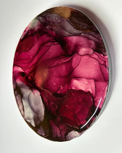 Round wall art of red, burgundy and metallic colours. Phoenix rising symbolism of rebirth and transformation.