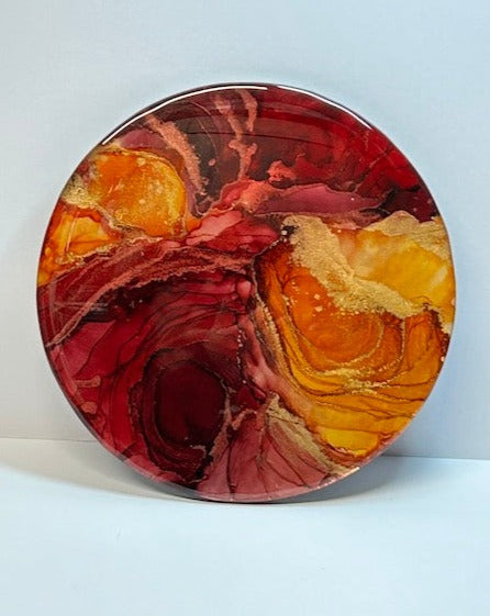 An aura expression - Horizon Of Flames is an abstract fluid art painting with lots of depth and hot colours. Its deep tones of red and orange fill the entirety of the circle. With themes of hope and rebirth by Inkandescent Arts.