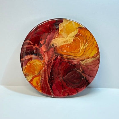 An aura expression - Horizon Of Flames is an abstract fluid art painting with lots of depth and hot colours. Its deep tones of red and orange fill the entirety of the circle. With themes of hope and rebirth by Inkandescent Arts.