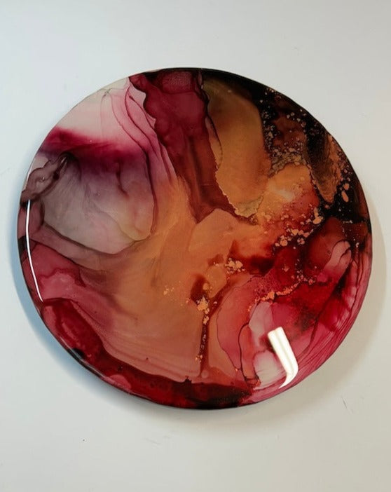 EMERGENCE - A fluid, abstract design 10’ Round, wall art painting. Representing a Mothers love, womb power and maternal instinct. With an infusion of wine and copper covered in resin, which gives it that beautiful, lustrous depth, shine and protection. Suffuse your wall with colour. By Inkandescent Arts. Original resin red abstract wall art expression..  Resin wall art , abstract in  warm colours.