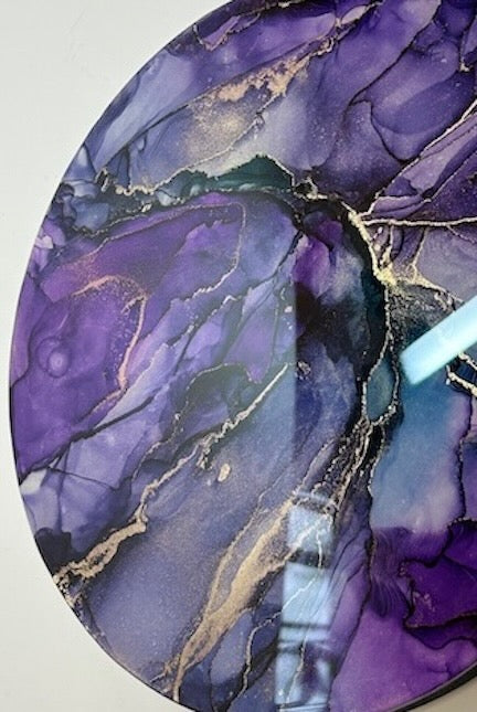 Round purple and gold abstract art piece on a white background