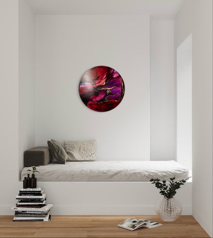A 10 inch round abstract painting on a white wall, over a bed and decorative items, in a modern bedroom interior, Featuring red plum and brass it adds a mystical and energetic feel to to your room.  Original art with symbolic meaning - rebirth and new beginnings. 