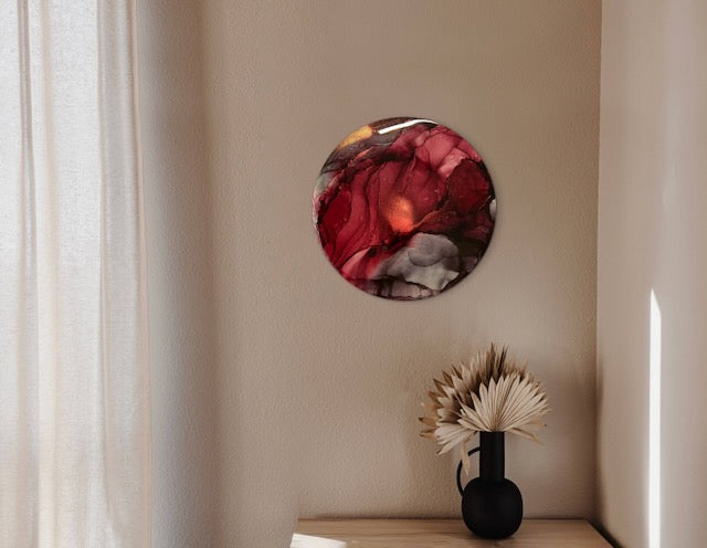 Burgundy abstract art adorns a bedroom wall. A symbolic rebirth exploration with roots in the mystical and mythical elements. This round wall art of warm colours would compliment neutral coloured walls in residential and commercial homes - Artwork by Inkandescent Arts.