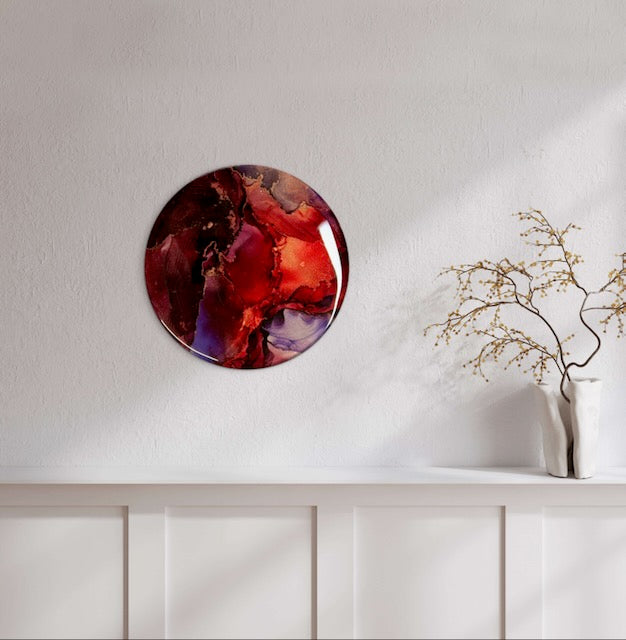 Metaphorical artwork of rising from the ashes in plum, scarlet and burgundy with metallic lines hung above a mantle. Healing symbolism through colourful wall art by Inkandescent Arts.