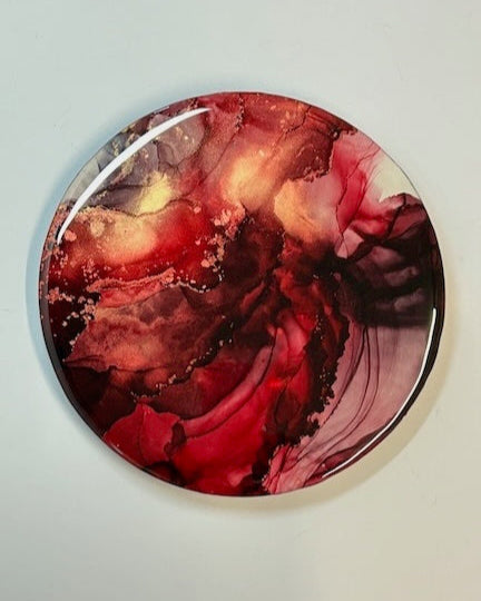 A dynamic circular abstract artwork in the fiery colours of red and gold. Symbolic of rebirth.