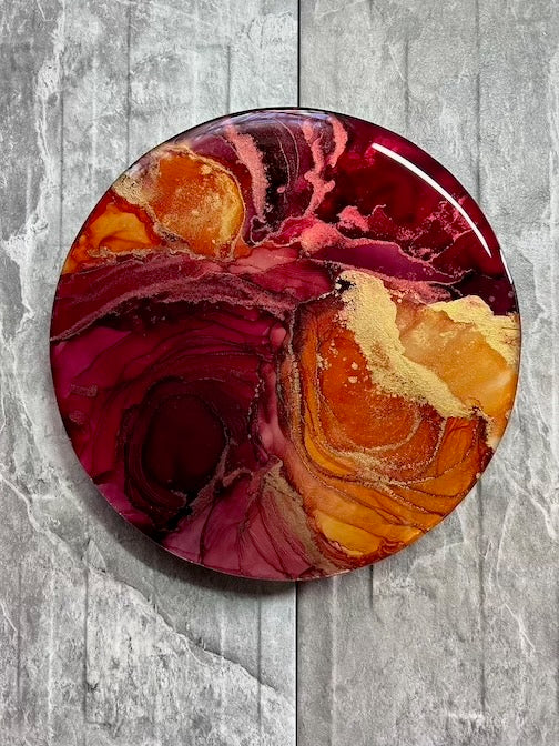 A round wall decoration of 10 inches. This contemporary abstract art features fiery red and sunset orange on a neutral coloured tile. Rebirth symbolism in art representing rebirth, passion and overcoming adversity. An encouragement to never give up on your dreams and to keep going.