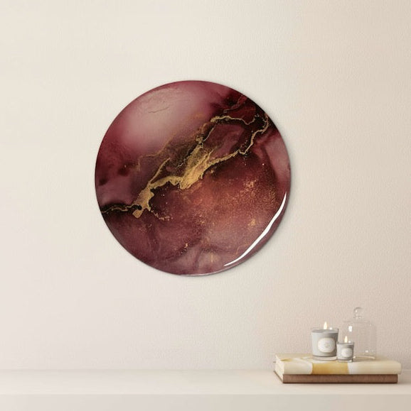 Death card and the phoenix of Greek mythology influenced circular art decorates a wall above a shelf.  Featuring rich maroon and black with golden fractures portraying an electric storm. Lightning symbolism representing rebirth and transformation by Inkandescent Arts.