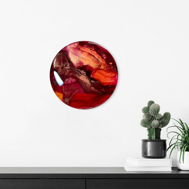 Small art in red hung above a mantle and plants. This rebirth artwork encourages healing and growth through embracing change. Death oracle art by Inkandescent Arts.