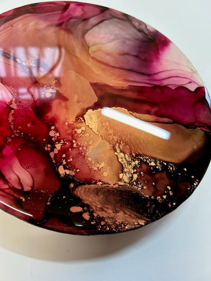 A closer view of colourful, original art designed for warm rooms. Displayed at an angle it highlights the dark and copper contrast that merges into fuchsia and magenta. Glossy, modern decor by Inkandescent Arts.
