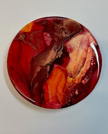 Abstract art; a mini 6 inch circular painting in fiery reds, gold and copper for small walls and shelving.
