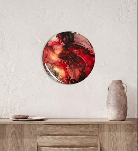 Circular wall art decor of red in a living room on display above a cabinet  This abstract artwork explores the phoenix and death card meaning in a tarot card deck, symbolism of life and death and beginnings and endings by Inkandescent Arts.