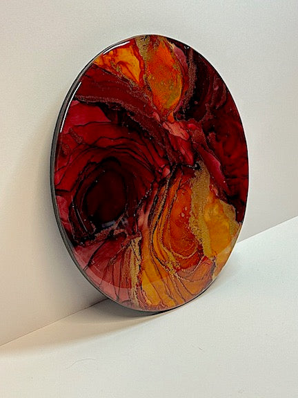 A symbolism of the Phoenix rising. Wall decor abstract paintings for the home in a round formation. Flame coloured in warm orange and a deep red. Metallic striations give form and detail whilst the lines and circles create depth.
