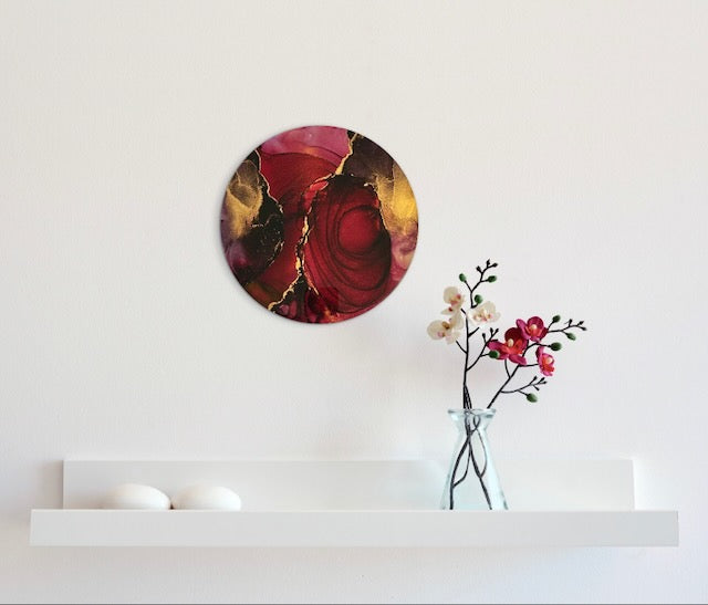 Hall wall art displayed on a wall above a shelf showing the warm and vibrant colours of scarlet, ink black and gold in a circle design. This abstract artwork is rooted in rebirth symbolism and represents the closing of one chapter in your life...and the opening of another...  Abstract artwork by Inkandescent Arts.
