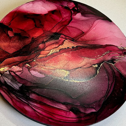 Close up of modern abstract art featuring deep red, purple and gold circular artwork - a symbol of healing, transformation and growth, based on death in tarot card readings and phoenix in mythology. Witchy art for warm and cosy spaces by Inkandescent Arts.