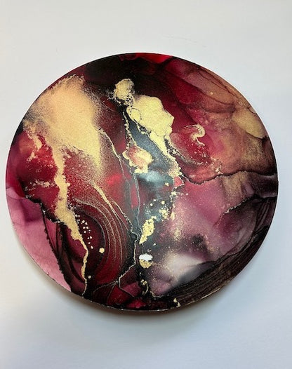 Ethereal artwork where dark red and inky black breaks into translucent dreamy colours. Brass lines and splats bounces the light.
