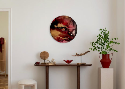 Round crimson red interior wall art hung above a table and ornaments. Rebirth and renewal symbolism art representing shedding skin - of releasing the past to make way for future and happiness, based on the phoenix myth by Inkandescent Arts.