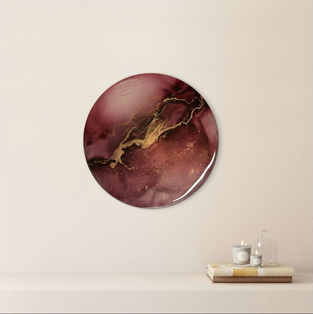 Round art decorates a lounge wall above a shelf.  A burgundy abstraction symbolic of rebirth, courage and resilience as we go through our darkest moments and find the light.