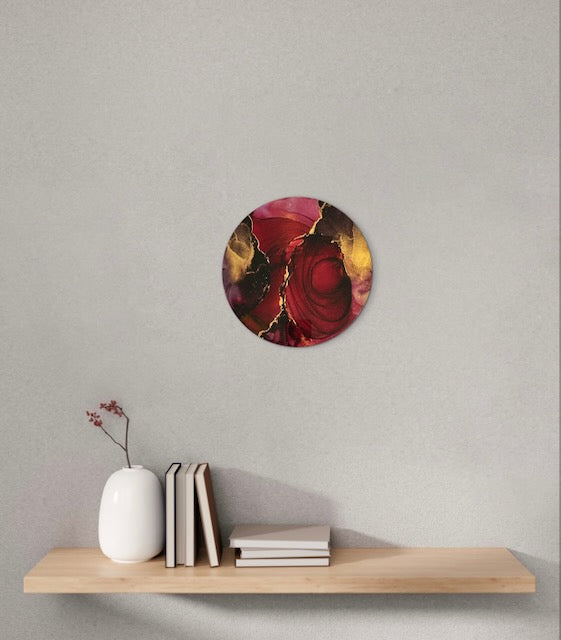Metaphorical artwork adorns a wall over a shelf. This red and gold, fiery, mixed media art speaks of rising from the ashes based on the Phoenix myth and death card interpretations - symbols of renewal, change and overcoming challenges by Inkandescent Arts.