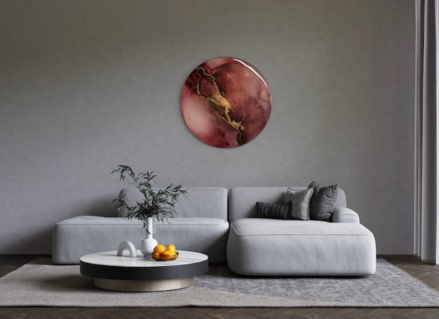 Modern living room wall art of burgundy, black with gold - representing lightning, striking across the painting, adorns a wall over a sofa. Abstract phoenix rebirth symbolism art representing endings and beginnings inspired by the phoenix fire bird and death, the major arcana card in tarot. A round painting of 25cm by Inkandescent Arts.