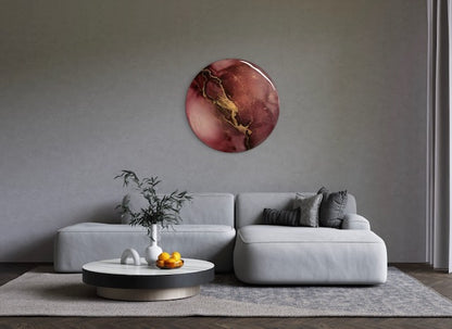 Modern living room wall art of burgundy, black with gold - representing lightning, striking across the painting, adorns a wall over a sofa. Abstract phoenix rebirth symbolism art representing endings and beginnings inspired by the phoenix fire bird and death, the major arcana card in tarot. A round painting of 25cm by Inkandescent Arts.