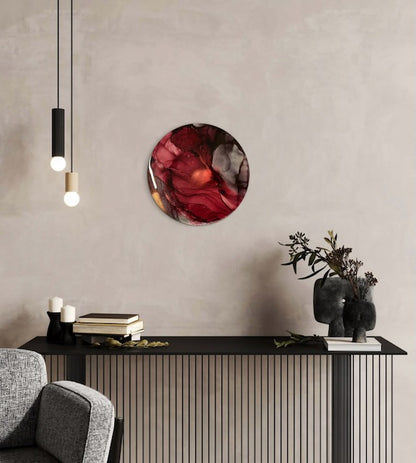Circular wall art of burgundy displayed above a radiator cover in a modern interior. A symbol of resilience when going through hard times this mystical symbolism artwork explores themes of metaphorical death and the Phoenix of myth and fable by Inkandescent Arts.