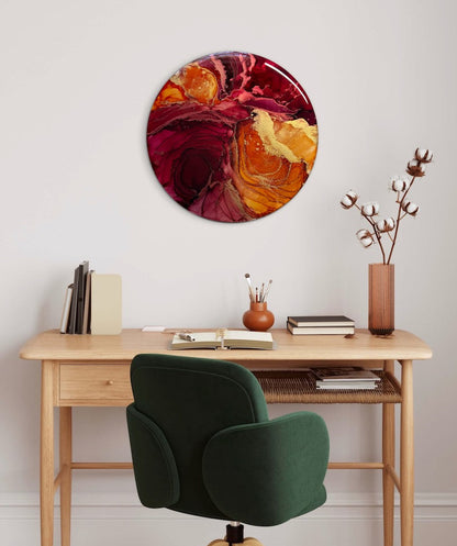 Wall art for an office adorns a wall over a wooden desk with a chair.  Circular wall art decor of orange, red and gold. Symbolism of life and death based on the tarot death card and phoenix symbolism by Inkandescent Arts.