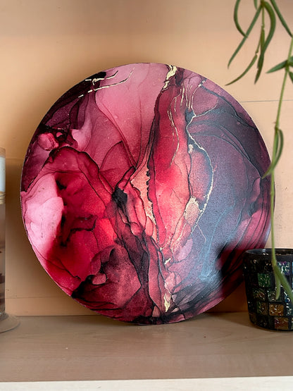 A fiery red, original abstract painting for sale on a shelf with candle holder and plant. Small art symbolising moving on based on the death card by Inkandescent Arts.