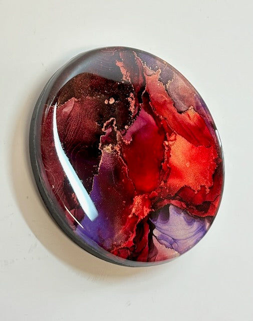 Original abstract artwork for sale displayed at an angle. This small painting of mystical purple, warm red and metallic has phoenix symbolism at its core and is a representation of rebirth  - A visual metaphor by inkandescent Arts.