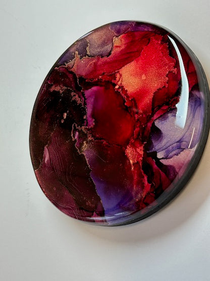 A small wall art creation in red and purple. Circular and ready to hang it is small but mighty. Ready to draw the eye and entrance with its beauty and colour.
