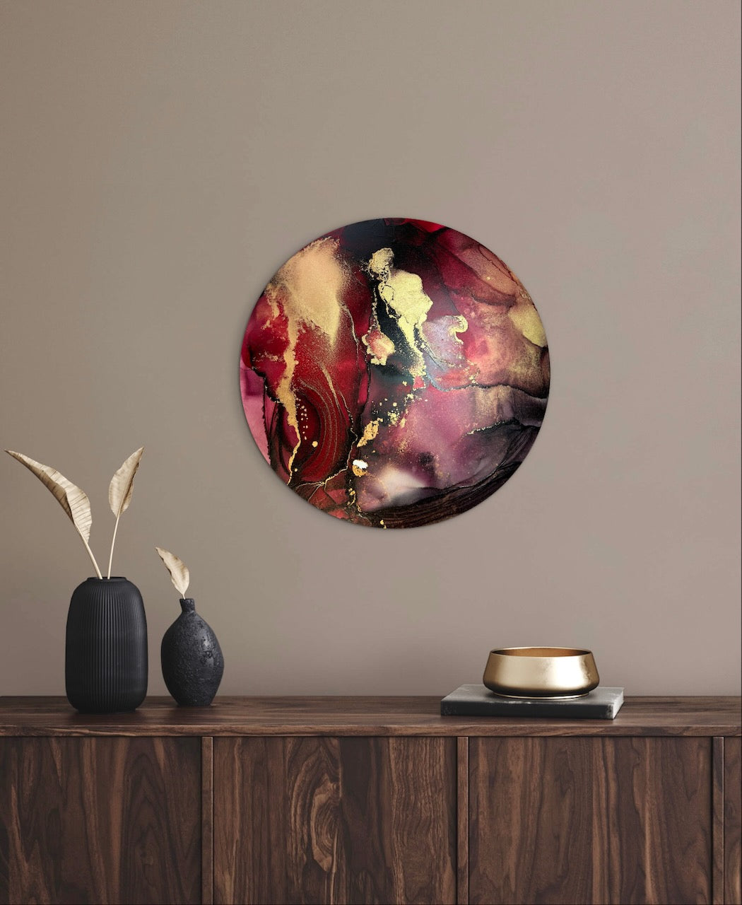 Circular abstract art decor on a neutral wall above a wooden console table with dark decorative items featuring black red and gold to help create a warm and cosy ambience to your room. Abstract goth art symbolic of transformation and rebirth.
