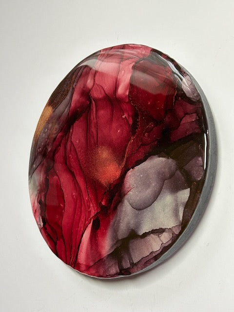 Modern abstract art, a closer view of an angled shot, showing the round depth and burgundy and grey colours. A representation of rebirth and transformation through the exploration of the death tarot card and Phoenix rising by Inkandescent Arts.