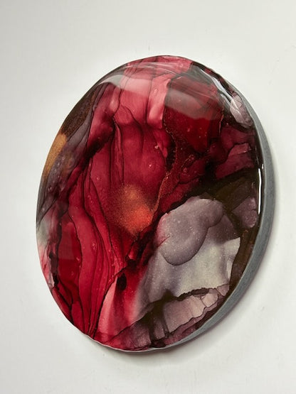 Modern abstract art, a closer view of an angled shot, showing the round depth and burgundy and grey colours. A representation of rebirth and transformation through the exploration of the death tarot card and Phoenix rising by Inkandescent Arts.