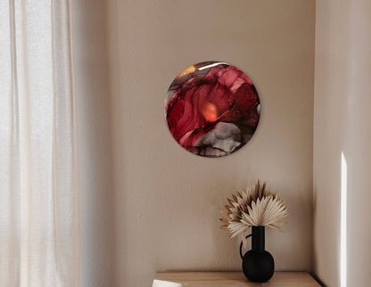 Round abstract art featuring red, black and brass colours on a bedroom wall above a bedside cabinet with dark ornaments. This motivational artwork encourages you to find yourself in moments of quiet, where we gather our strength and forge through our darker times.
Rebirth symbolism in art for your home.