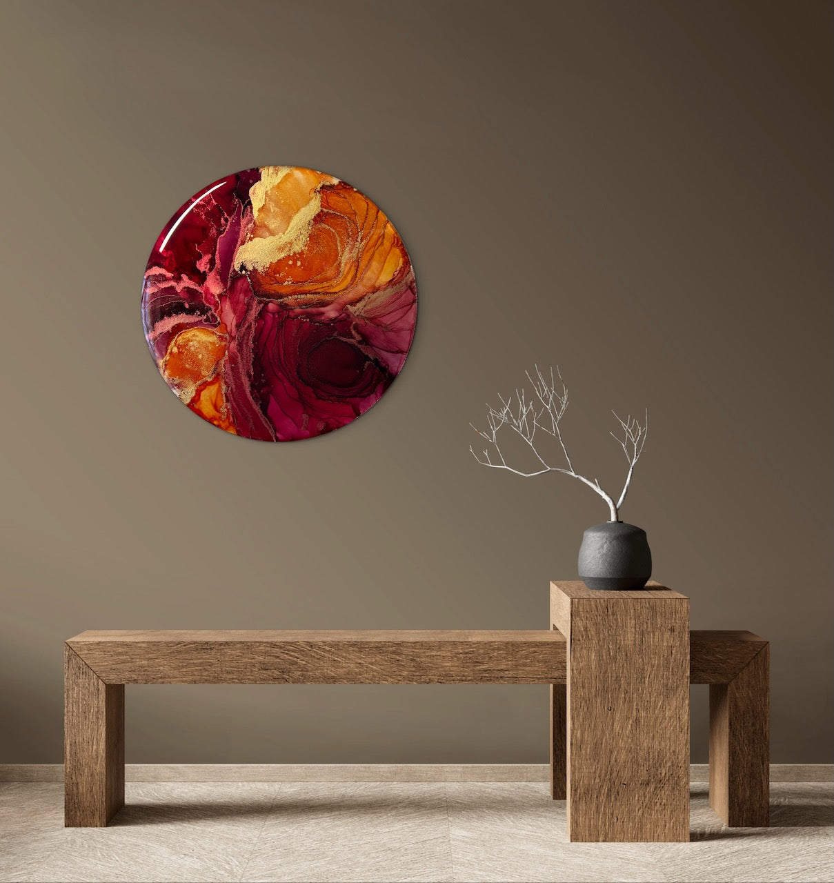 Orange and red, round, abstract wall decor on a brown wall with a wooden bench and vase. A painting of rebirth based on the fire phoenix and the death card.... transformation symbolism by Inkandescent Arts.