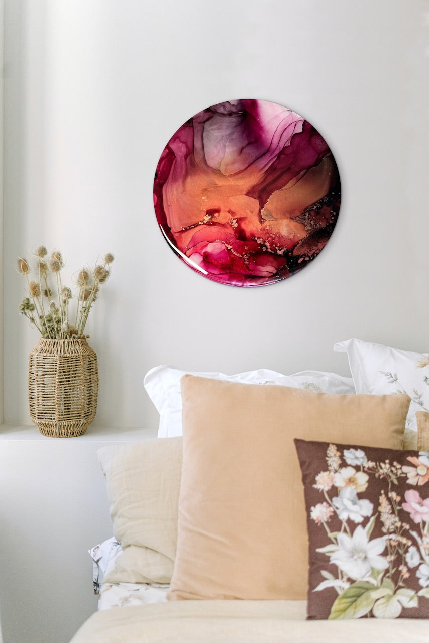 Abstract symbolism art of transformation and rebirth; wall decor art of metallic copper and rose pink on a white living room wall over cushions and sofa. Round artwork for cosy and warm rooms.