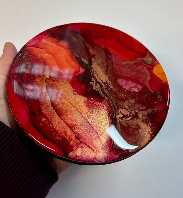 A small painting of red and gold held by hand angled to show lush colour and detail. Abstract art that speaks of the transitions in life as we go through major changes - by Inkanescent Arts.